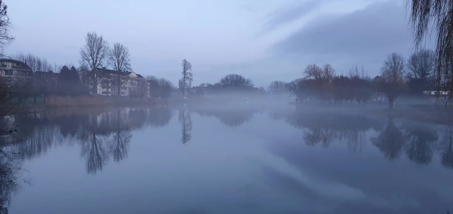 a body of water sitting under a cloudy sky