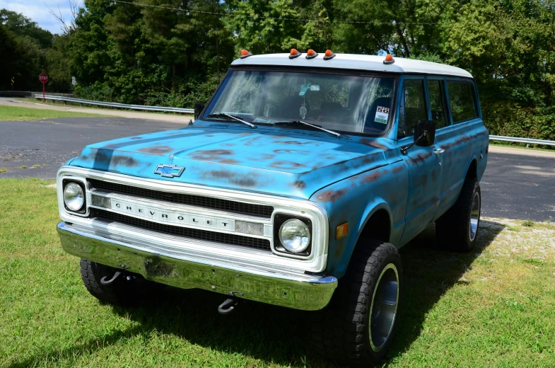 an older rusty truck sitting in the grass