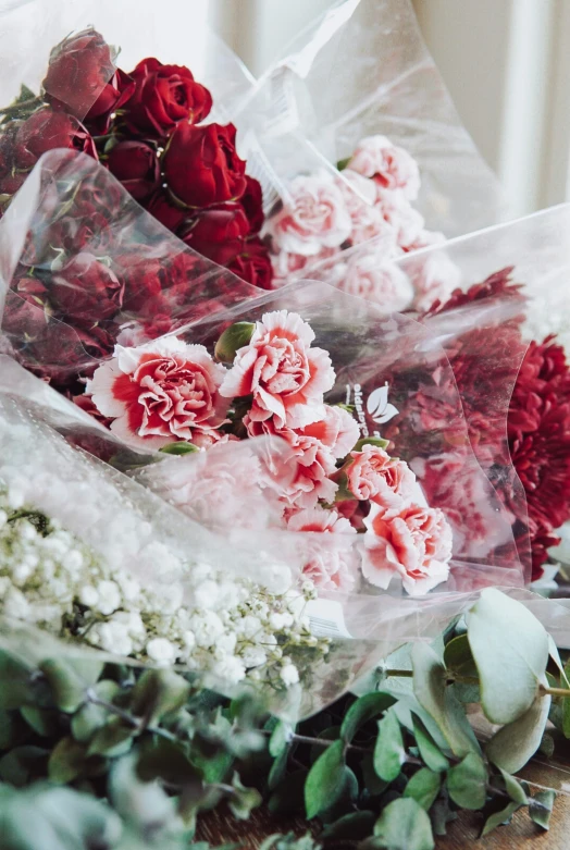bunches of pink and red flowers in plastic wrap