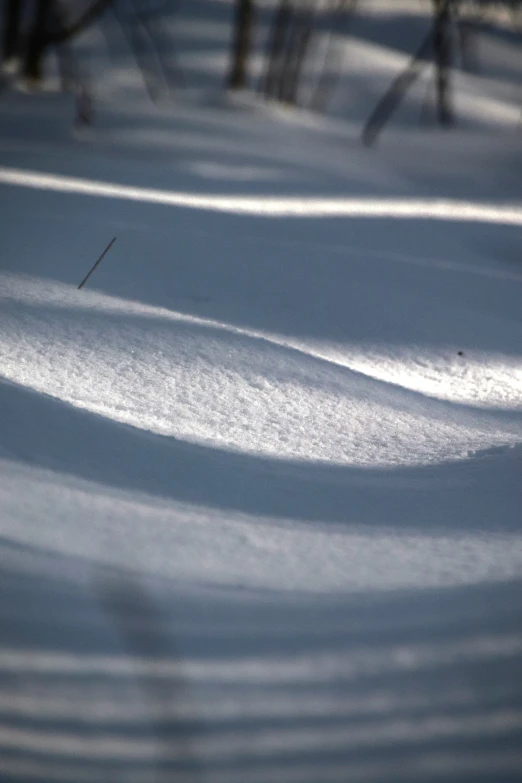 someone on a snowboard going down a snowy hill