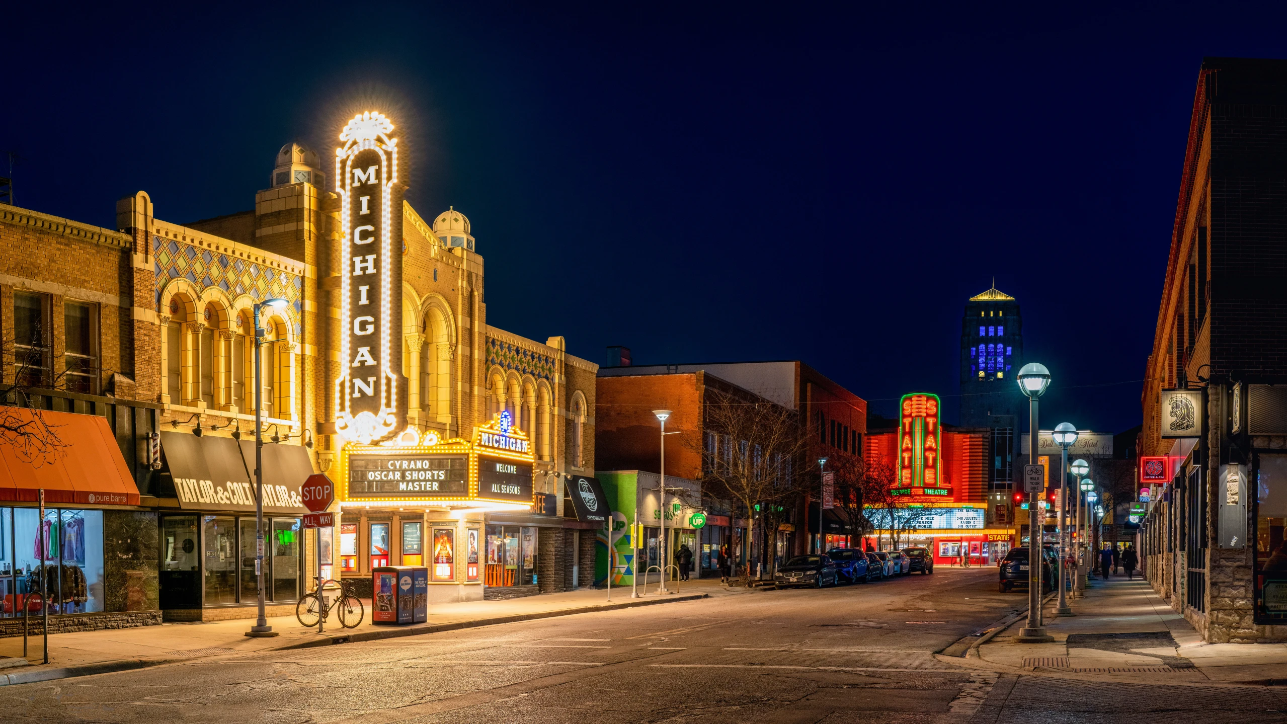 the street has lots of lights and stores along it