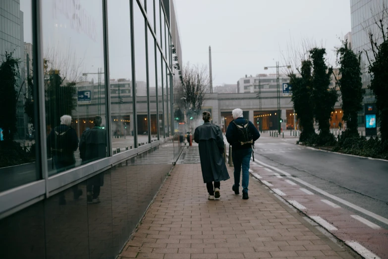 a couple of men walking down a sidewalk