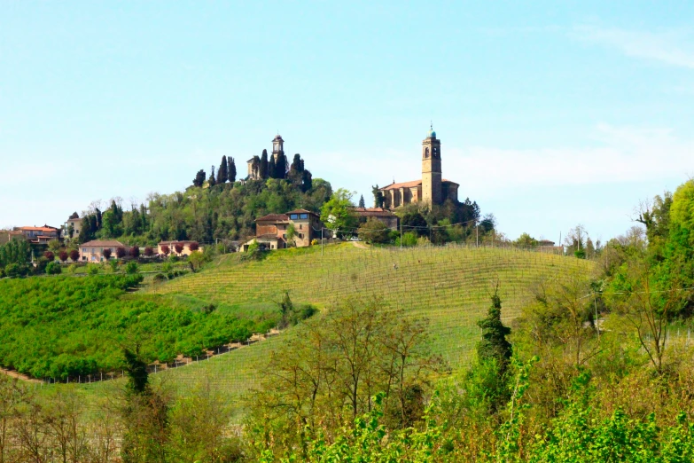 a small village on a grassy hill with tall buildings on top