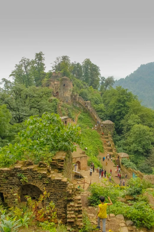 tourists on a path to an old structure built into a cliff