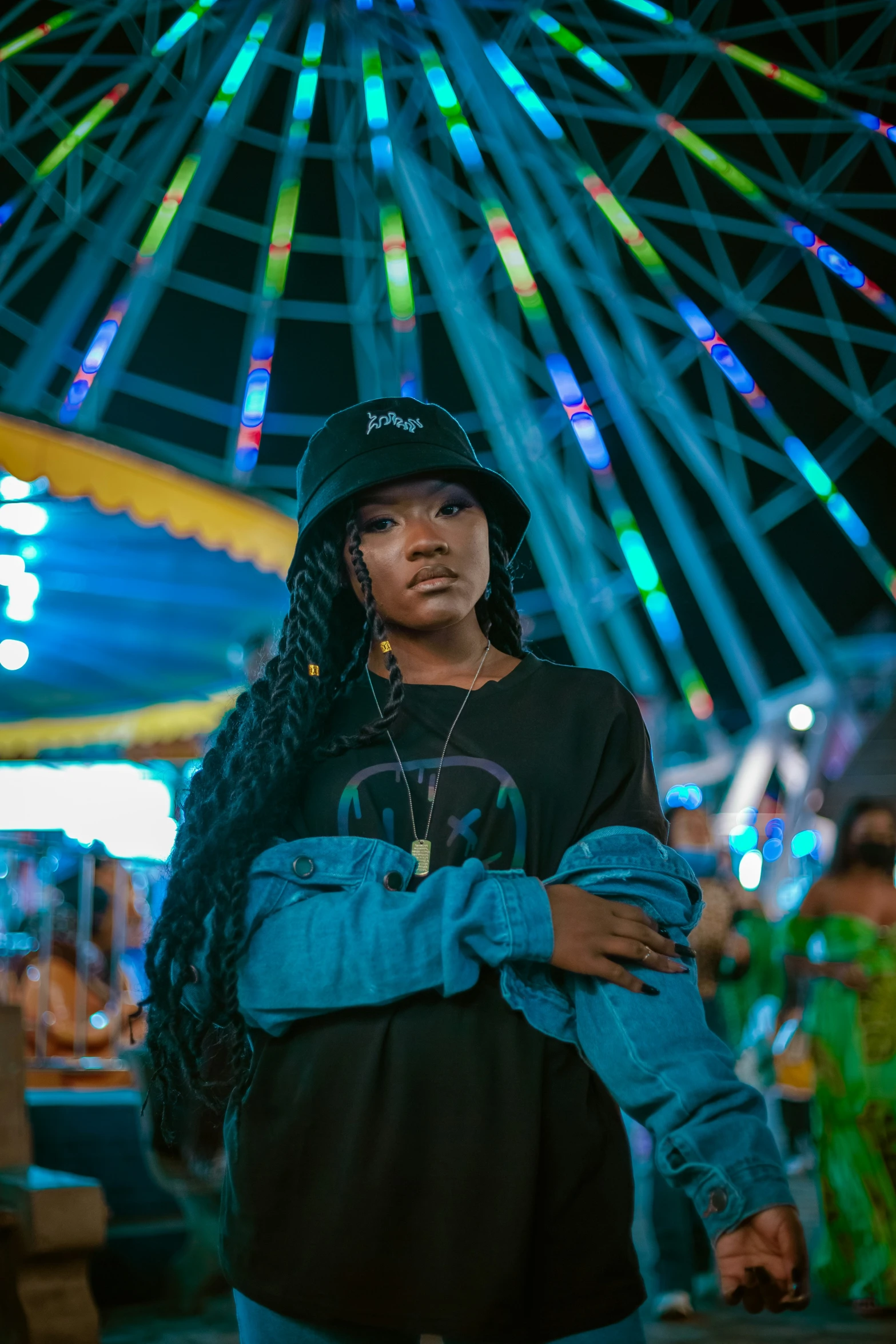 a woman posing in front of a carousel at night