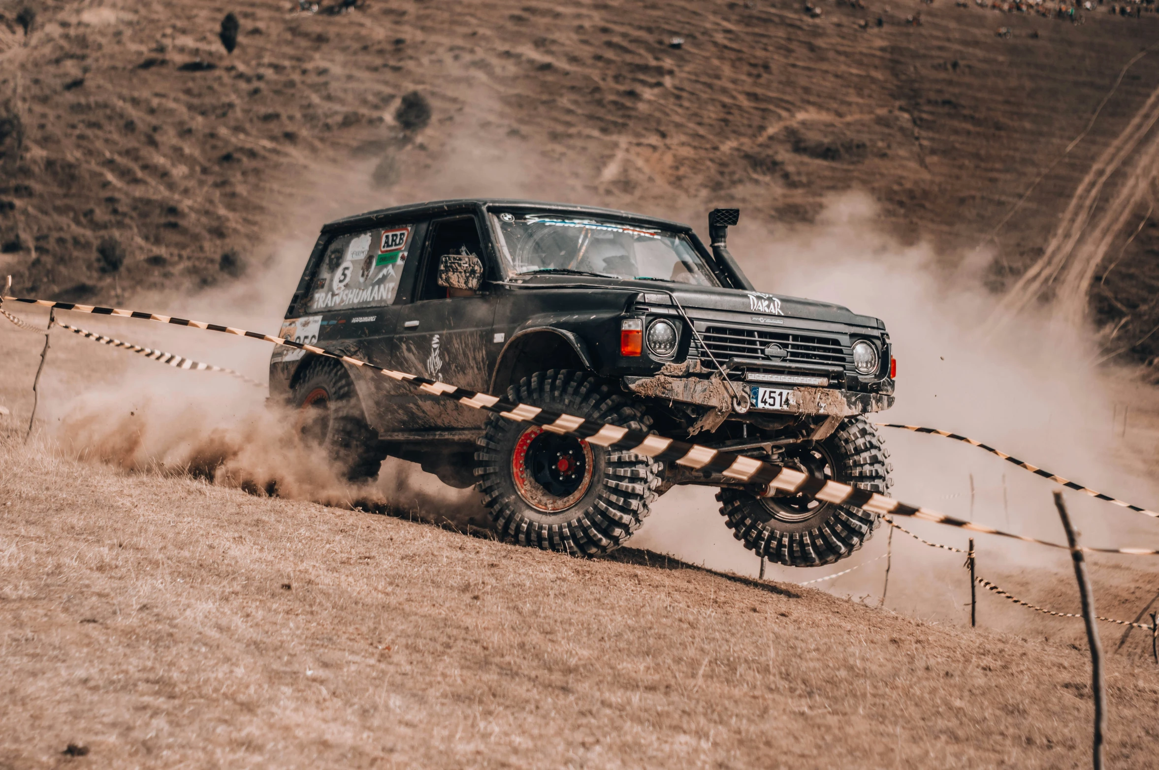 a black truck in motion as it goes around a track