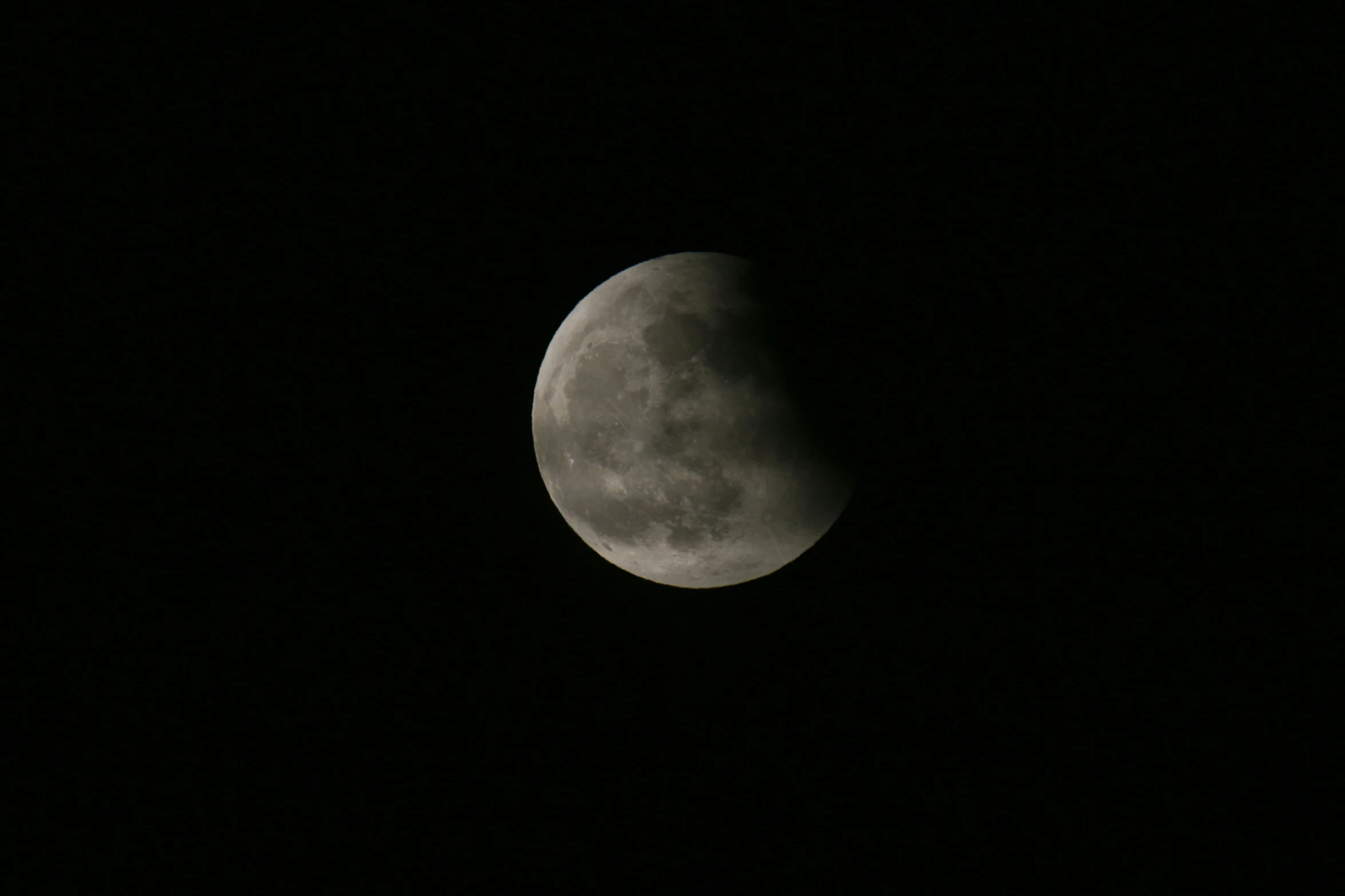 the moon is seen through a darkened sky