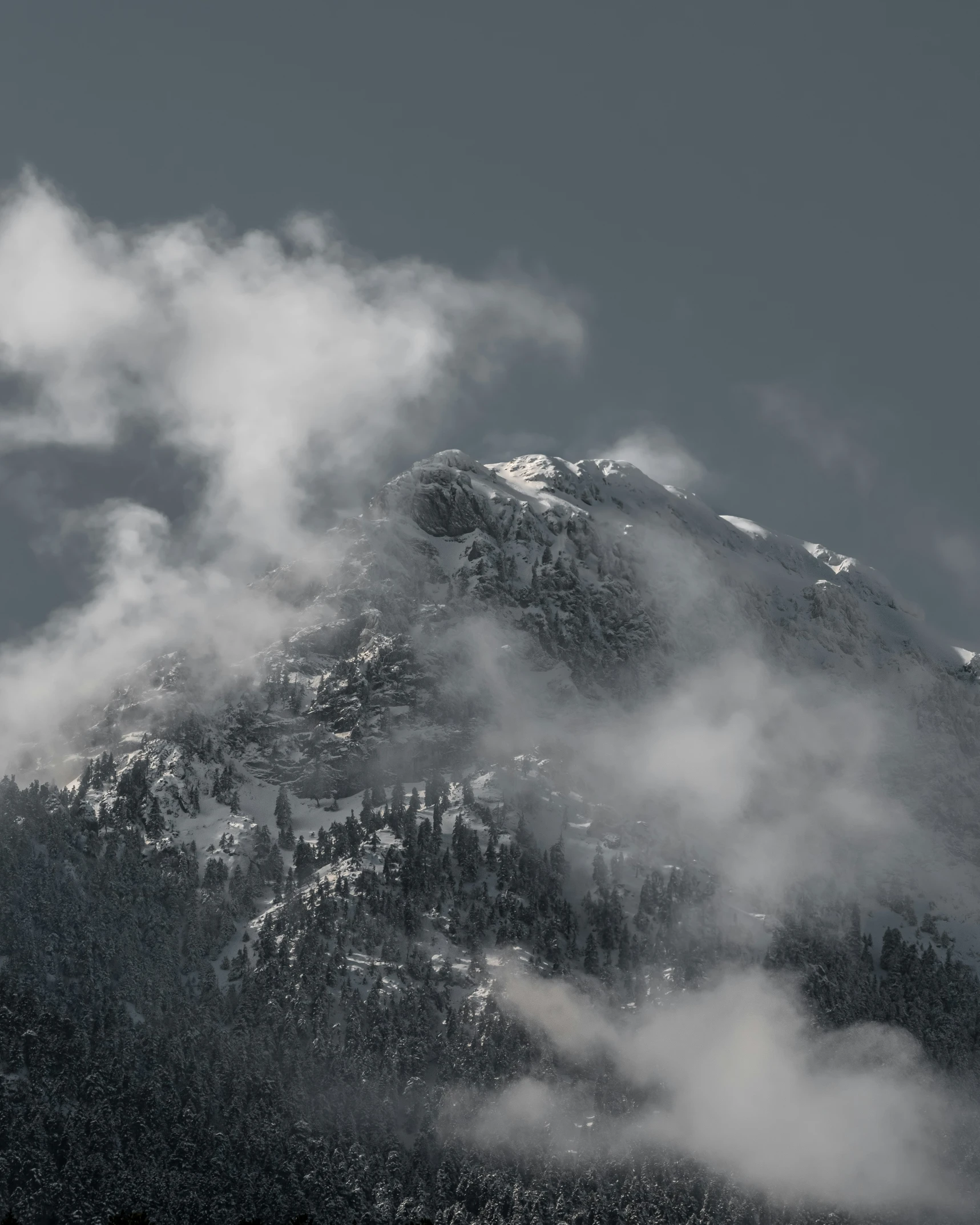 a large snowy mountain covered in lots of cloud