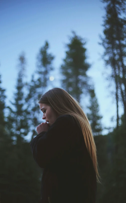 a woman in the dark smoking a cigarette