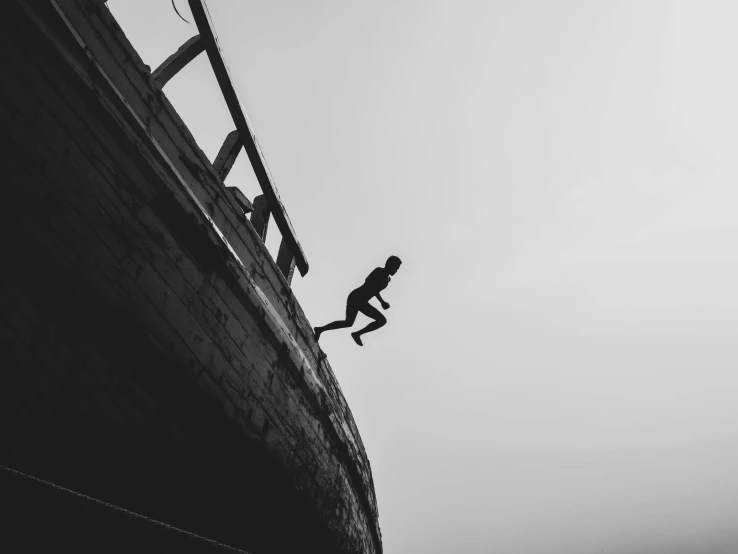 a man walking up the side of a wooden ramp on top of a boat