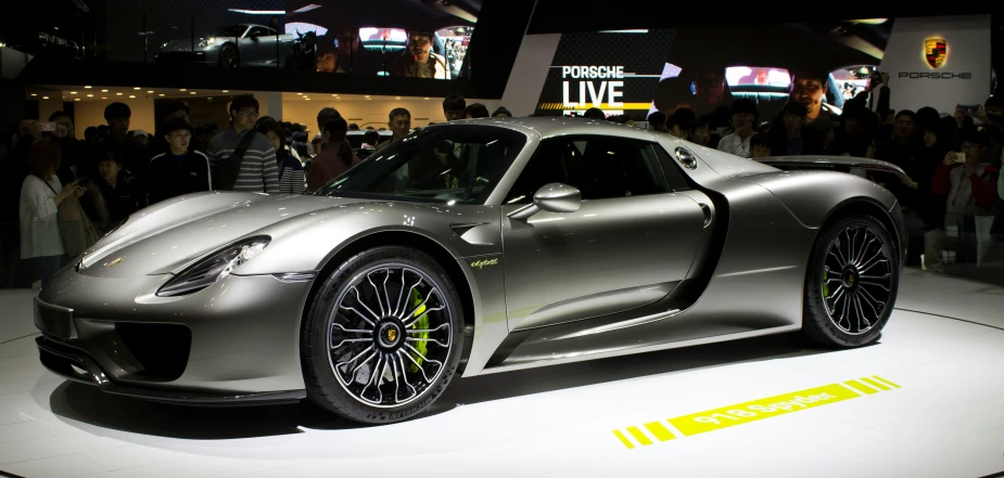 this silver sports car is on display at a show