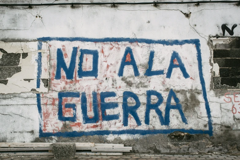 graffiti written on the side of a building reads no alla euera