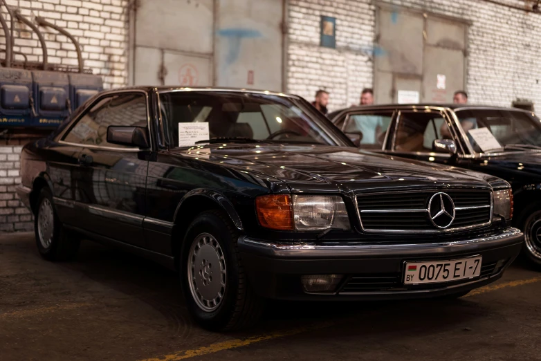 two mercedess are parked side by side, but the rest one has license plate