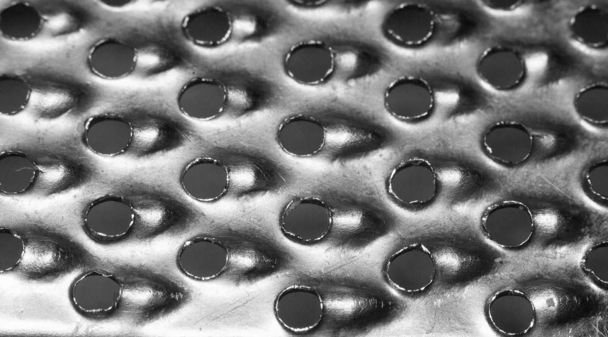 black and white image of metal sheet with circles on it