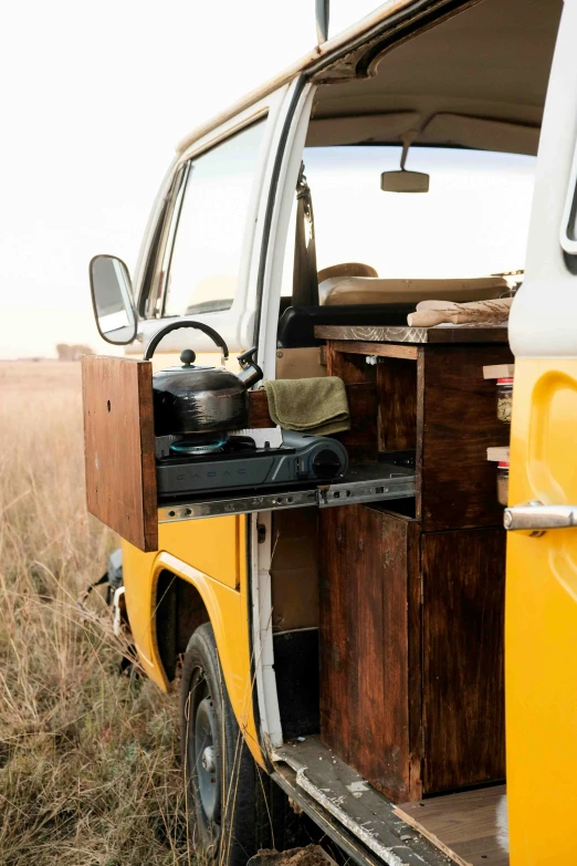 an open van door on the side of an empty field