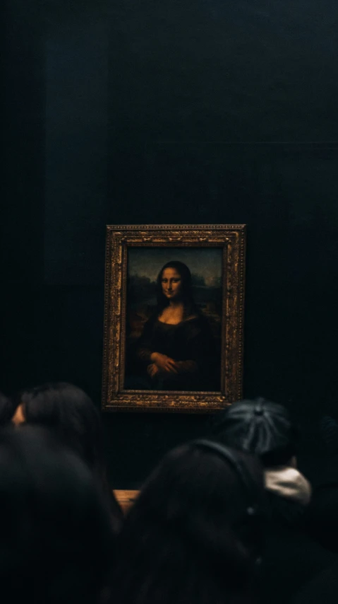 a man in a black shirt is staring at a painting