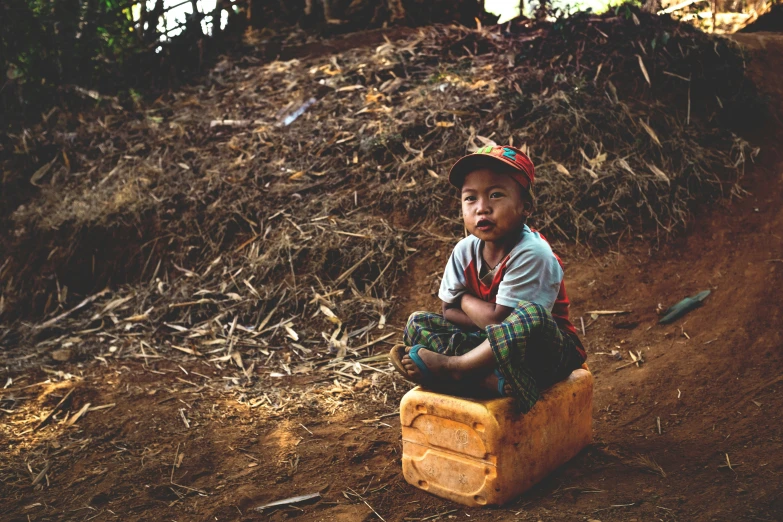 there is a small boy sitting in an old suitcase