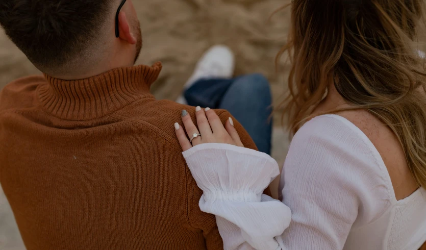 a man and woman looking back while holding hands