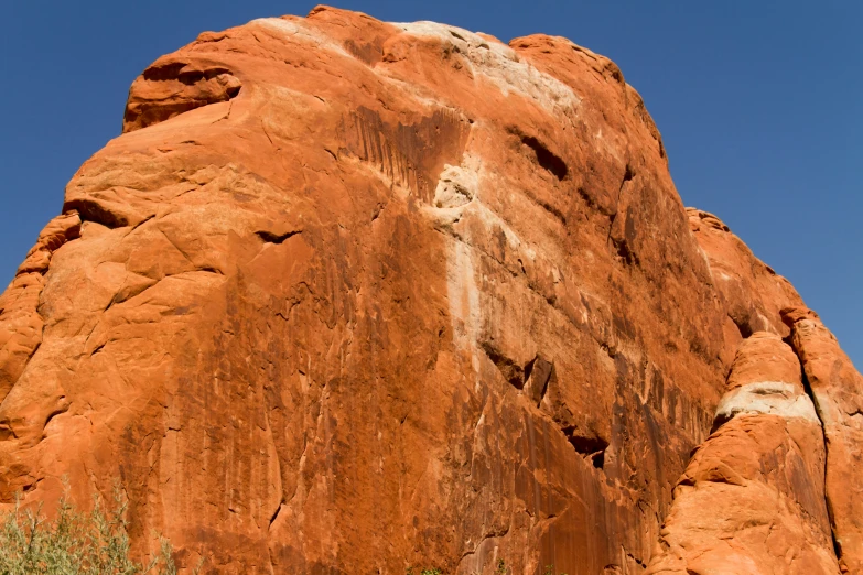 a tall red rock face under a blue sky