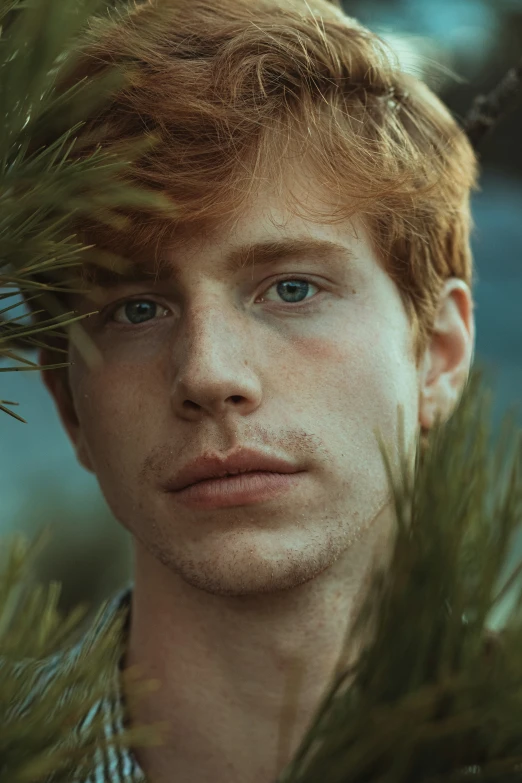 a young man with freckles looking straight ahead in a portrait
