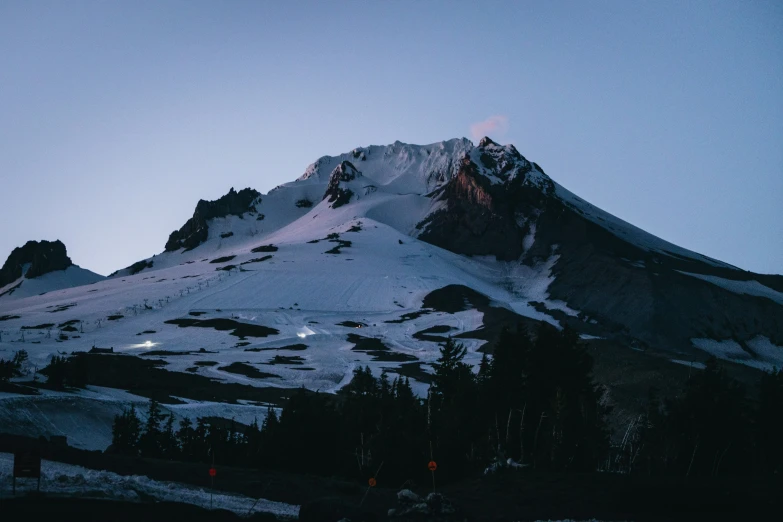 the mountain covered with snow is lit up by lights