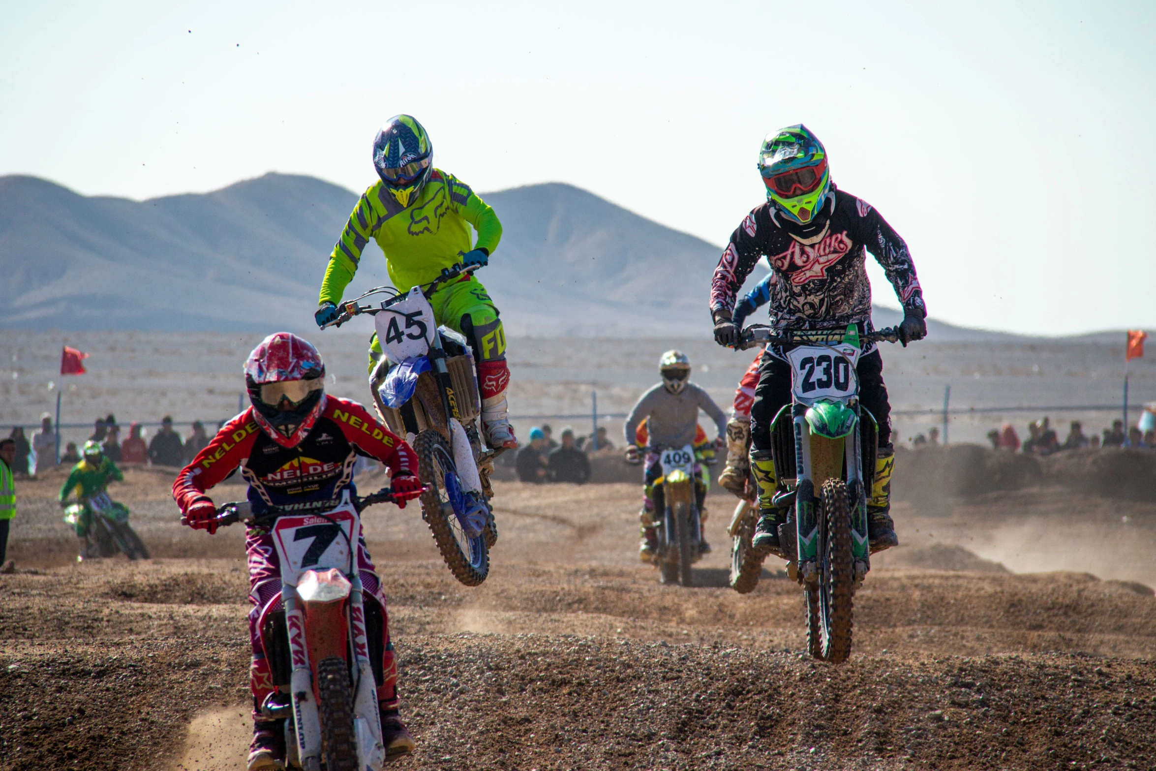 three riders on motorbikes riding through the desert