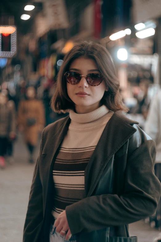 a woman with dark sunglasses is walking in a crowded shopping center