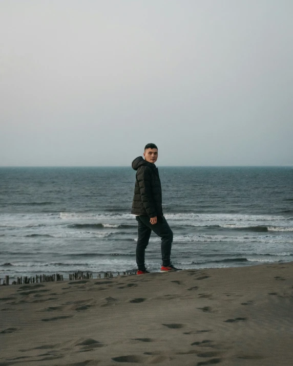 a man standing on top of a sandy beach