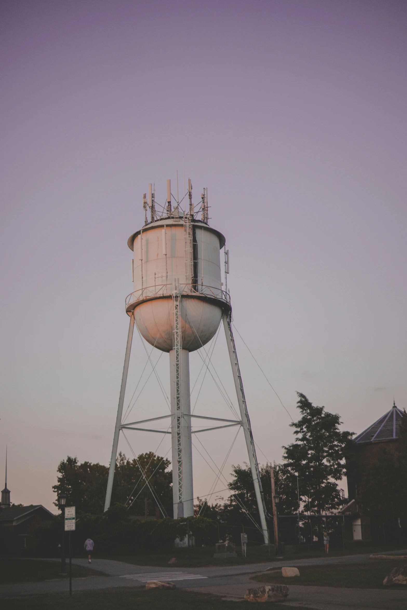 an old water tower sits next to trees