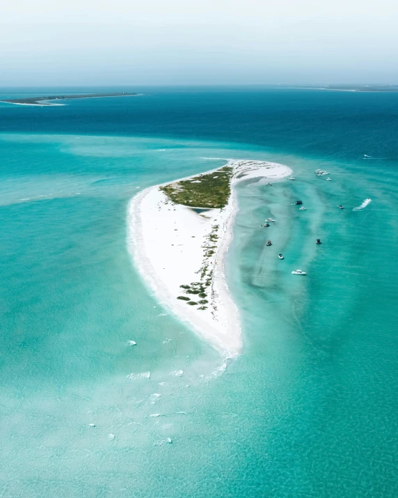 aerial view of a white sand beach surrounded by clear water