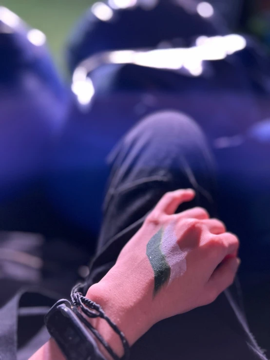 a hand is shown with green and white makeup on it