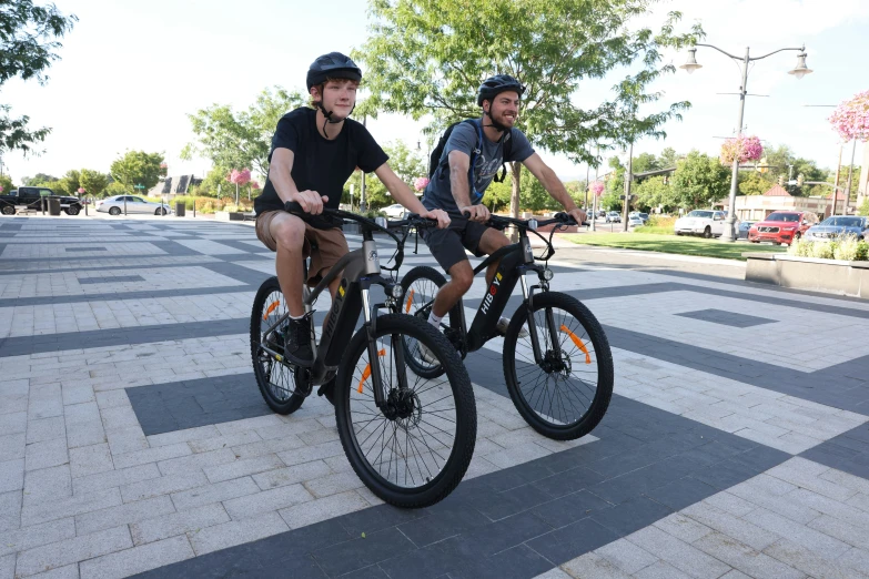 two people on bicycles, two riding backwards, and one being on the opposite bike