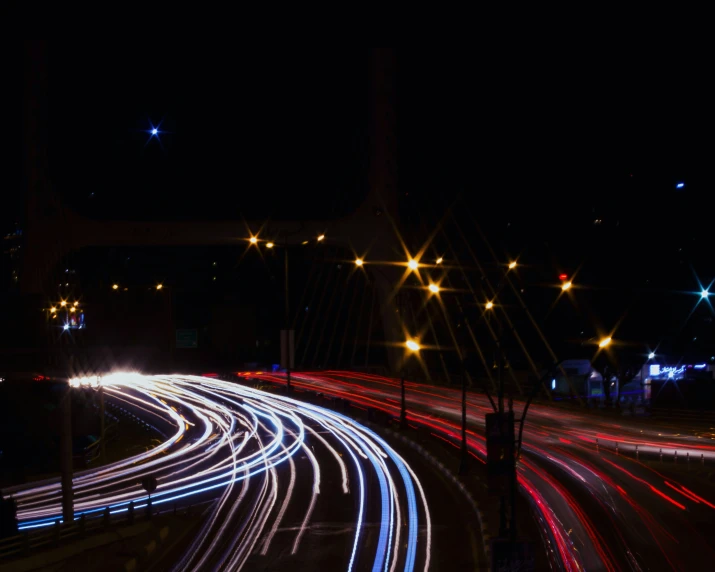 cars and trucks move along a street at night