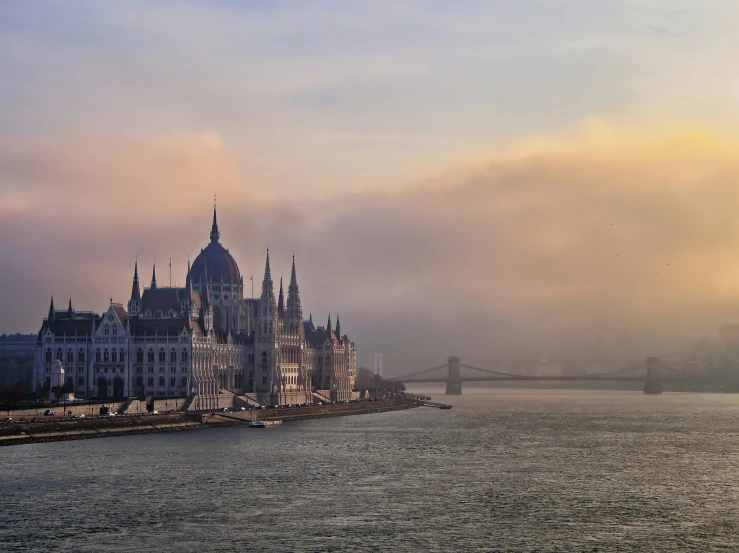 a castle near the river at sunset