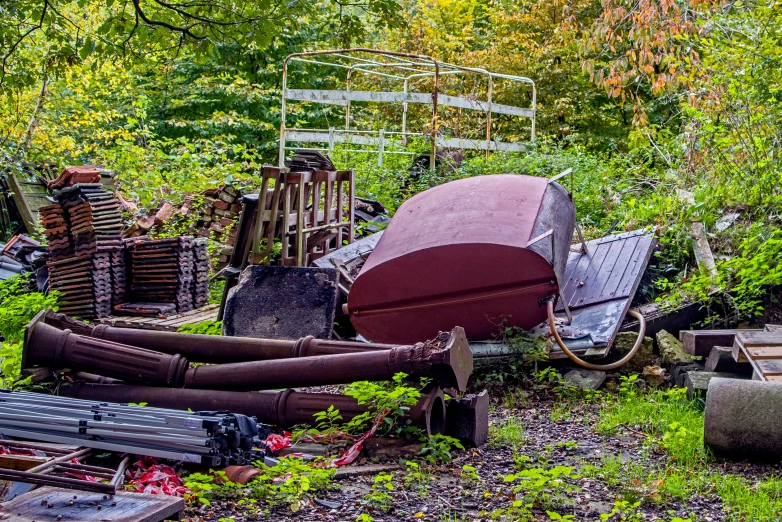 an abandoned boat and other objects in a junk yard