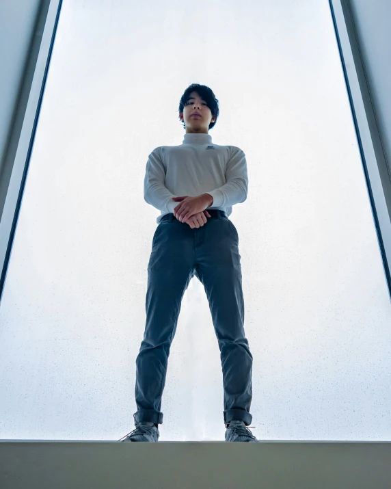 man with hands clasped in front of glass floor