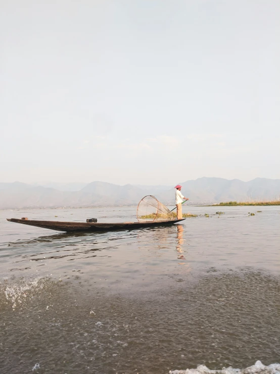 the person is rowing a long boat on the water