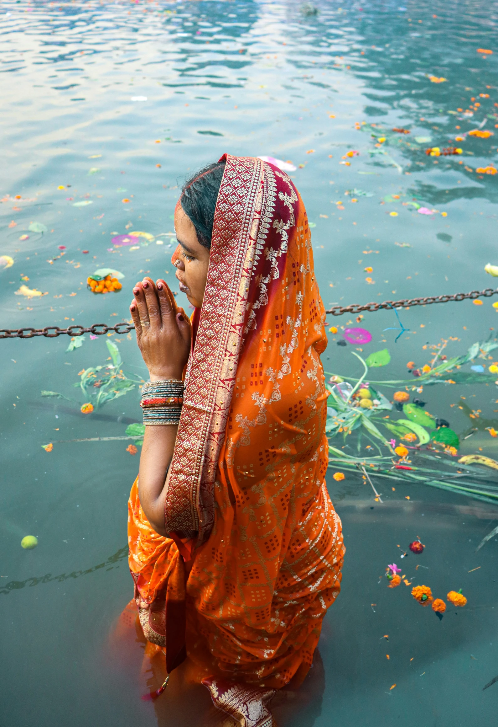 a woman in orange clothes sitting on top of a lake