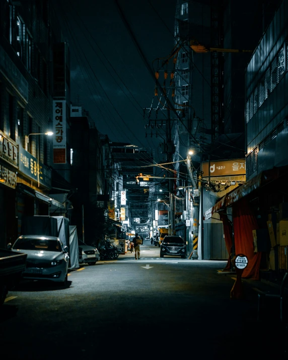 a night scene shows a person standing in the alley