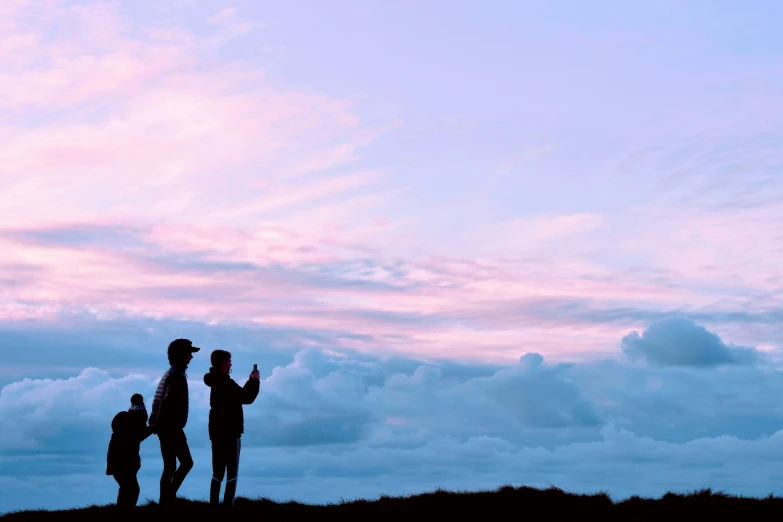 three people are standing with their kites in the air