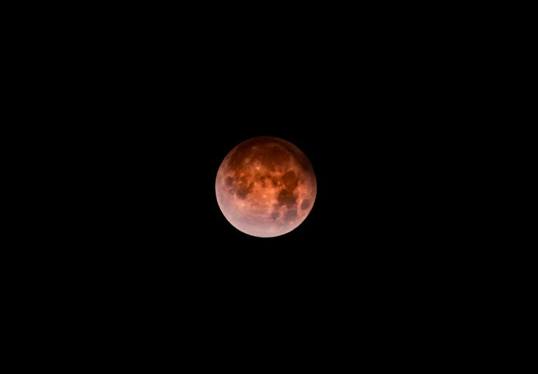 a dark night sky with a large red moon