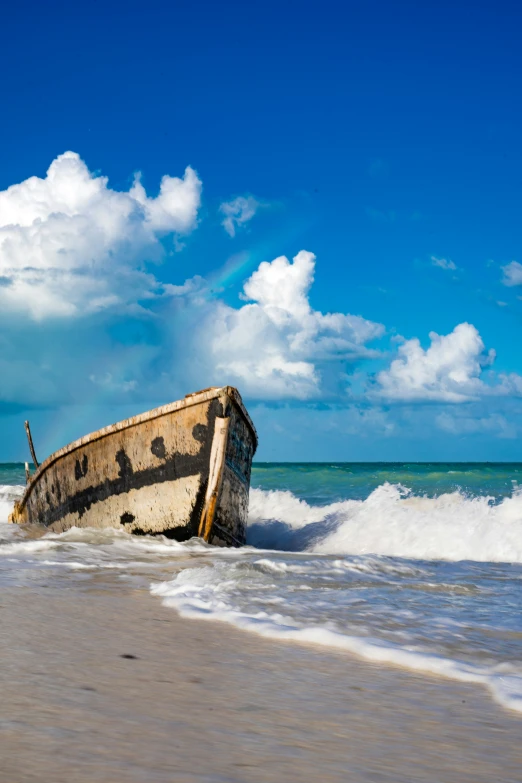 the ocean is full of waves and the remains of an old boat sitting on top of it