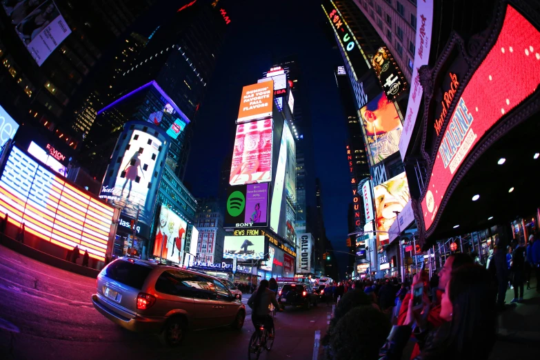 the people walk down the street where brightly lit buildings