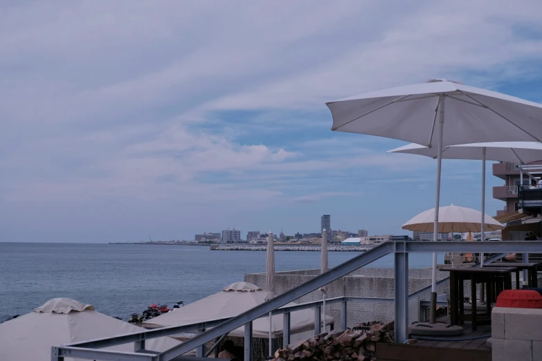 a white umbrella sitting next to the ocean on a beach