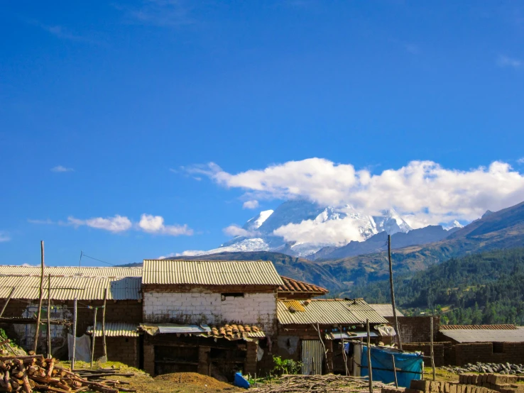 an old house sits in front of the mountains