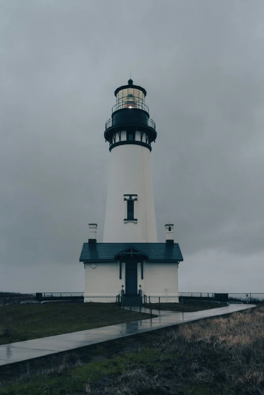 a lighthouse sitting in the middle of a grassy field