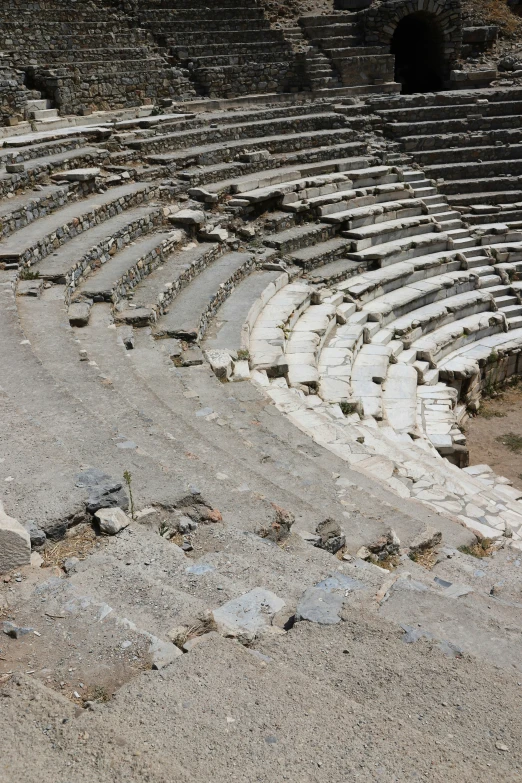 there is only one man walking in an empty seat at an ancient roman theatre