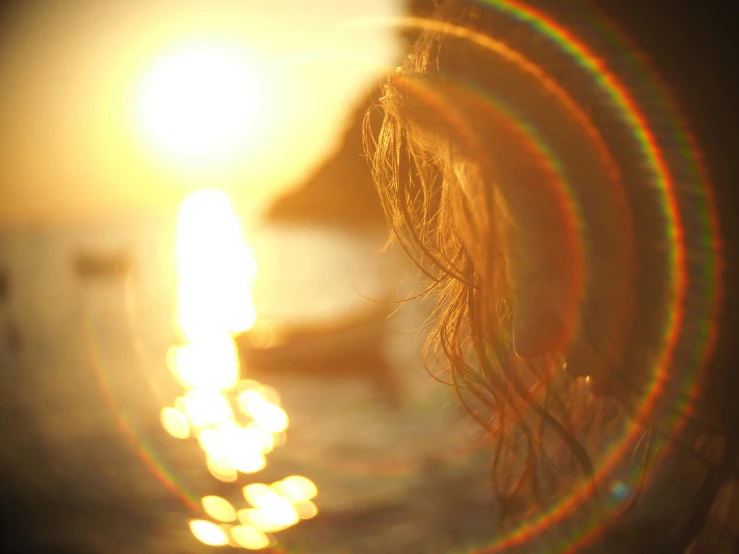 a woman's face and back lights at a sunset beach