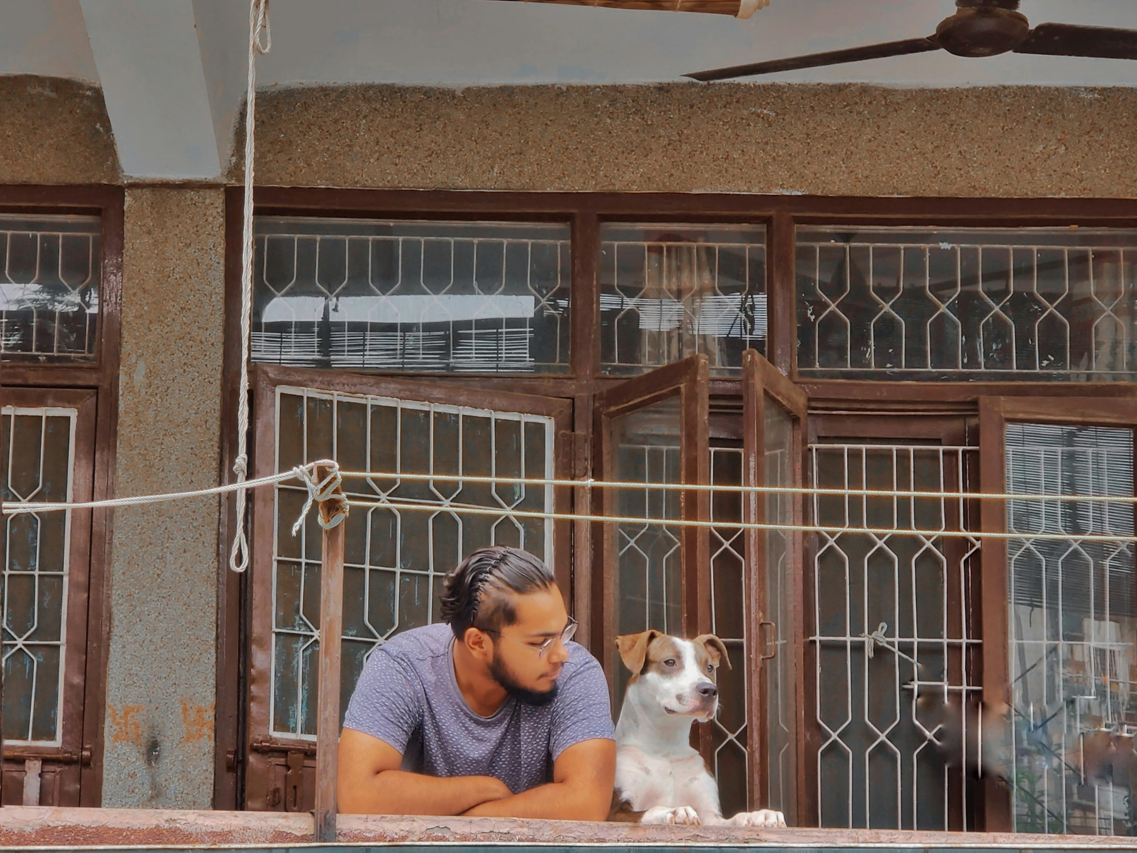 a man with a dog near a metal fence