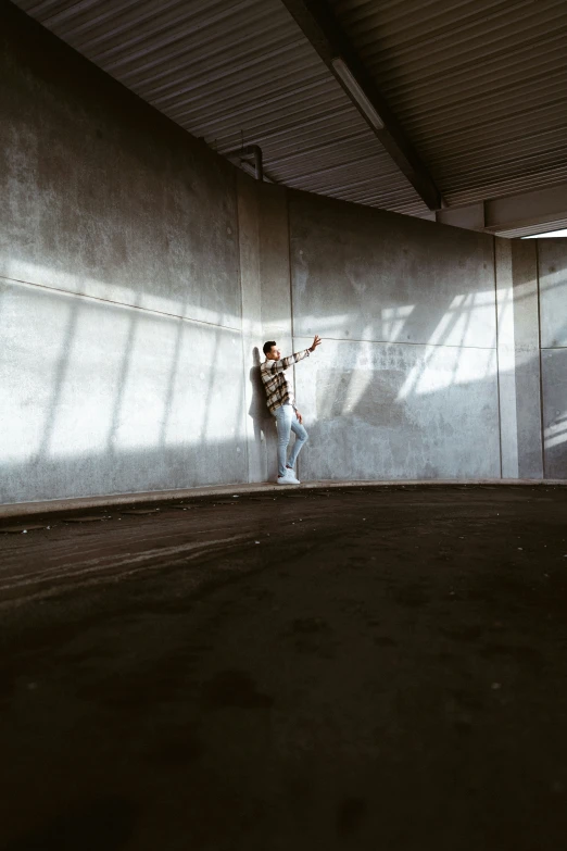 a man is standing against the wall and looking down